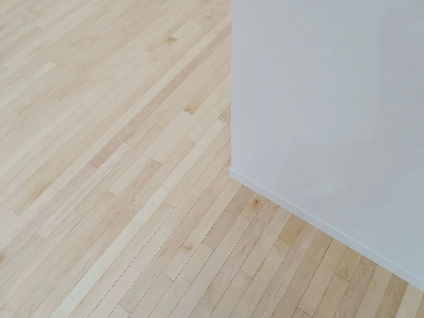 Ljust vinylgolv i ekimitation mot en vit vägg
